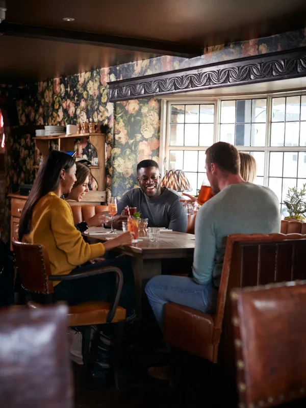 Group Of Friends Meeting For Lunchtime Drinks In Traditional English Pub