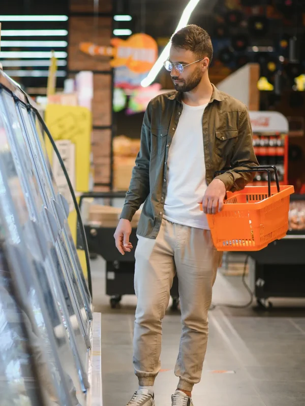 Young man buying looking at food selection in a modern supermarket or grocery store